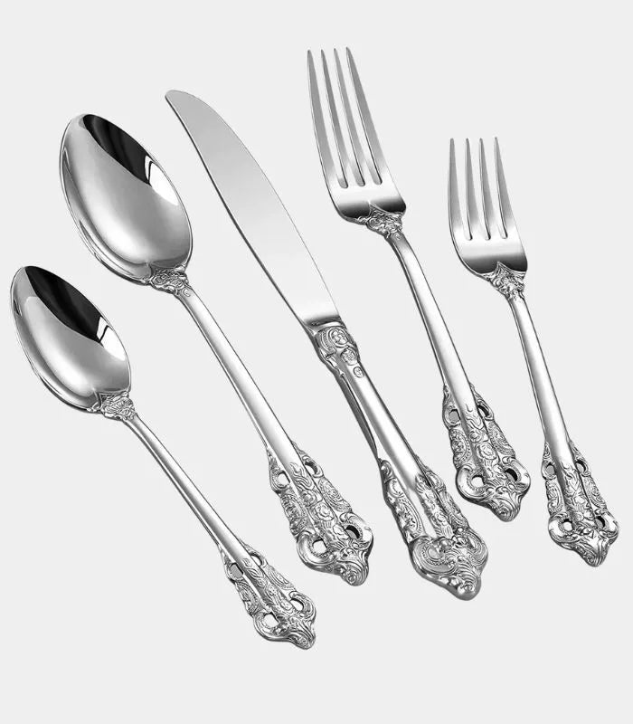 A 20-piece cutlery set with intricate scrollwork design on the handles, including dinner knives, dinner forks, salad forks, soup spoons, and teaspoons.