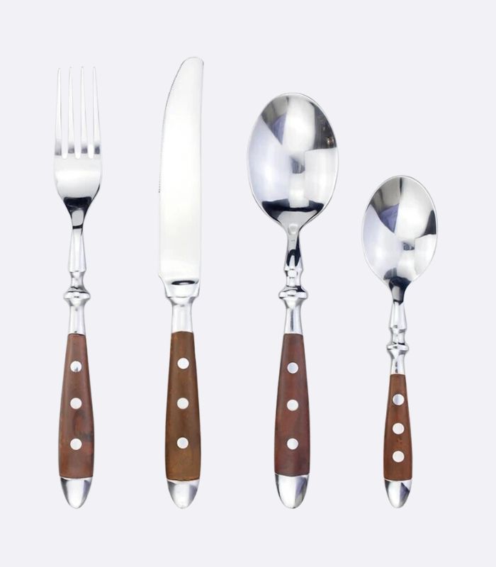 A set of flatware including knives, forks, spoons, and teaspoons with silver-colored metal parts and brown handles with white rivets.